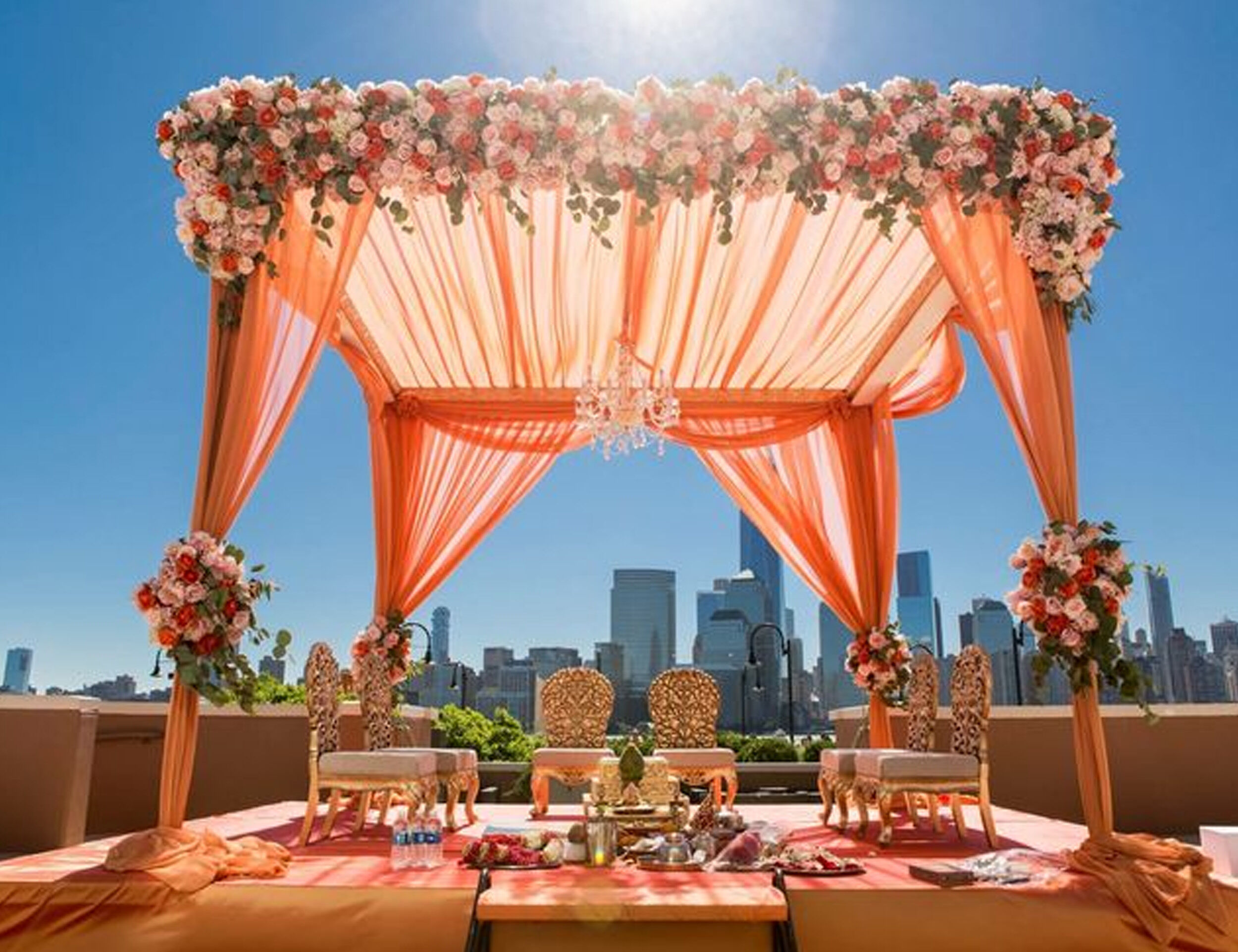Elegant orange-themed wedding reception decor with a breathtaking cityscape backdrop